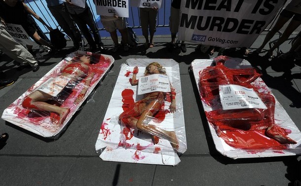 PETA (People for the Ethical Treatment of Animals) demonstrators mimic typical meat packages with signs reading, "Meat Is Murder," in Times Square in New York on July 27, 2010. The activists lying nearly naked on large trays and covered with clear plastic will feature oversized price stickers that warn, "Billions of Animals Are Abused and Violently Killed Because You Eat Meat". AFP PHOTO/TIMOTHY A. CLARY (Photo credit should read TIMOTHY A. CLARY/AFP/Getty Images)